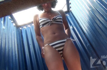 Брюнетка показывает гениталии в пляжной кабинке