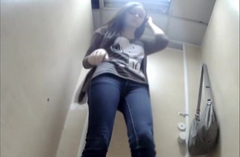 Вид спереди на писающую девушку в женском туалете