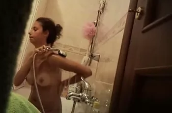 Загорелая женщина с упругими сиськами моется в ванной